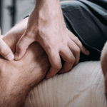 hands massage the muscles around an athlete's knee